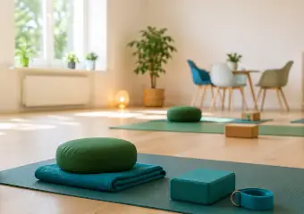 Ein heller, freundlicher Raum mit Yogamatten und Sitzkissen auf dem Boden.